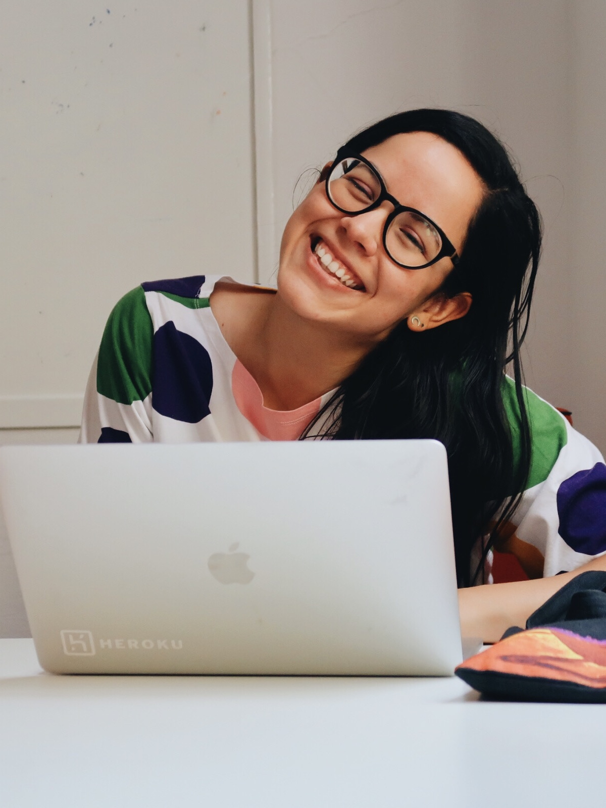 Me with a big smile and a colorful shirt in front of a laptop.